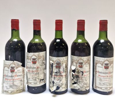 quatre bouteilles de vin sont alignées sur une surface blanche