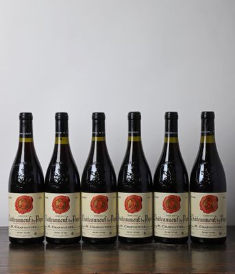 six bouteilles de vin sont alignées sur une table en bois