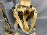a bag with a strap attached to it sitting next to a trash can