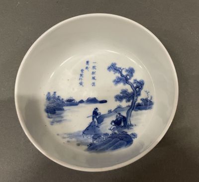 blue and white porcelain bowl with a scene of a man on a boat