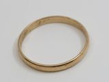 gros plan d'une bague en or sur une surface blanche