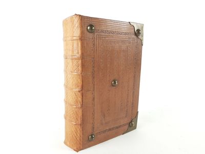 an old book is sitting on top of a white surface