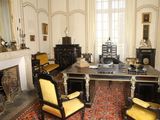 an image of a room with a desk, chairs, and a fire place