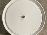 an overhead view of a white clock on a tile floor