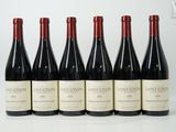 six bouteilles de vin sont alignées sur une table