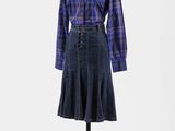 une chemise et une jupe à carreaux bleus et violets posées sur un présentoir pour mannequin