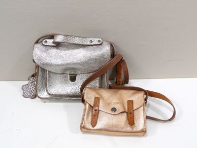 two bags that are sitting on a white table
