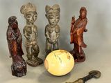 three figurines that are sitting next to a yellow egg