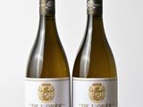 deux bouteilles de vin blanc posées sur une table en bois