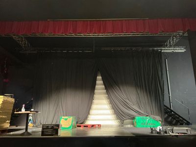 a stage set up with a stage curtain and a stage chair