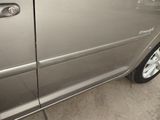 a silver car parked in a parking lot with its door open
