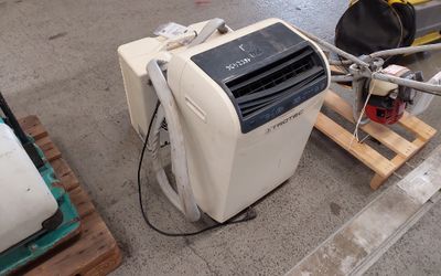 a small air conditioner sitting on a pallet in a warehouse