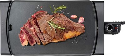 une photo d'un steak sur un barbecue, agrémenté d'herbes et d'épices