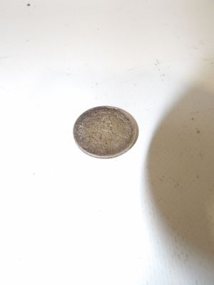 a small coin sitting in a sink next to a white sink