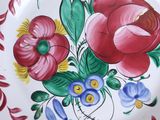 a colorful plate with flowers painted on it on a table