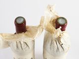 two bottles of wine that are wrapped in paper
