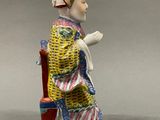 an image of a figurine of a man sitting on a chair