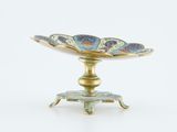 a gold plate with a flower on it on a stand
