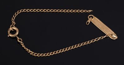 a close up of a gold chain bracelet on a black background