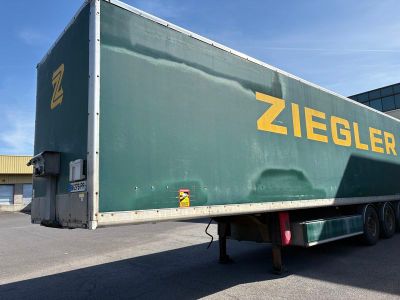 une semi-remorque verte arborant un logo Ziegler jaune sur le côté