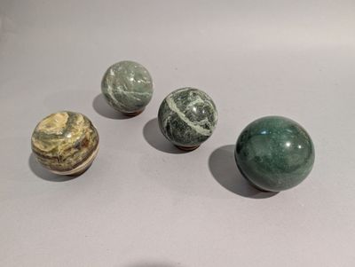 Plusieurs types de billes sont disposées sur une surface blanche.