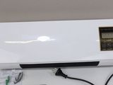 an air conditioner sitting on top of a white table next to a charger