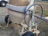 a cement mixer sitting on the side of the road