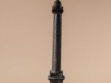 a bronze statue of a lighthouse on a wooden base