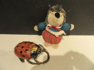 une petite peluche posée à côté d'une coccinelle