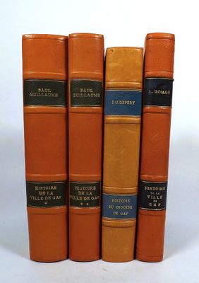 five books that are lined up on a white surface
