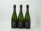 trois bouteilles de vin posées sur une table l'une à côté de l'autre