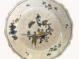 une assiette blanche décorée d'un oiseau et de fleurs