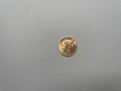 gros plan d'une pièce d'or sur une surface blanche