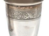 a silver cup that is sitting on a white surface