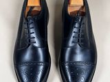 the black leather shoes are lined up on a white surface