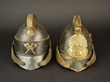 two helmets that are sitting side by side on a black surface