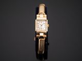 a close up of a gold watch with a chain around it