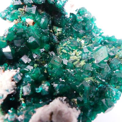 Gros plan sur un amas de cristaux verts posés sur une surface blanche