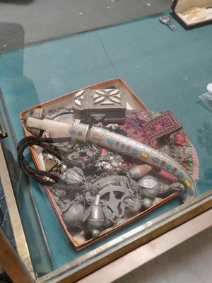 une table en verre avec un plateau de bijoux et une paire de ciseaux