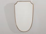 un miroir à cadre doré accroché à un mur blanc