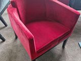 two red chairs sitting next to each other on a carpeted floor