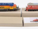deux trains miniatures exposés sur une surface blanche