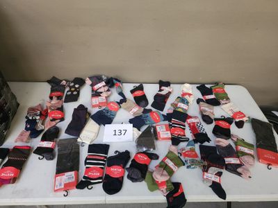 de nombreuses paires de chaussettes posées sur une table, avec leurs étiquettes de prix