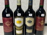 quatre bouteilles de vin sont alignées sur un plan de travail