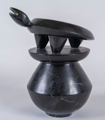 un vase noir surmonté d'un serpent