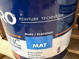 an orange and blue bucket of paint sitting on a pallet