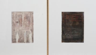 Deux tableaux accrochés à un mur blanc : l'un est de couleur marron et l'autre est en noir et blanc.