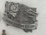 two badges and a pin on a white surface