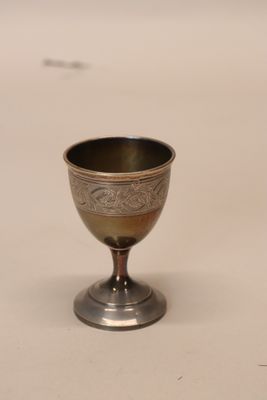 une coupe en argent posée sur une table blanche