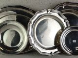a lot of silver plates sitting on a shelf